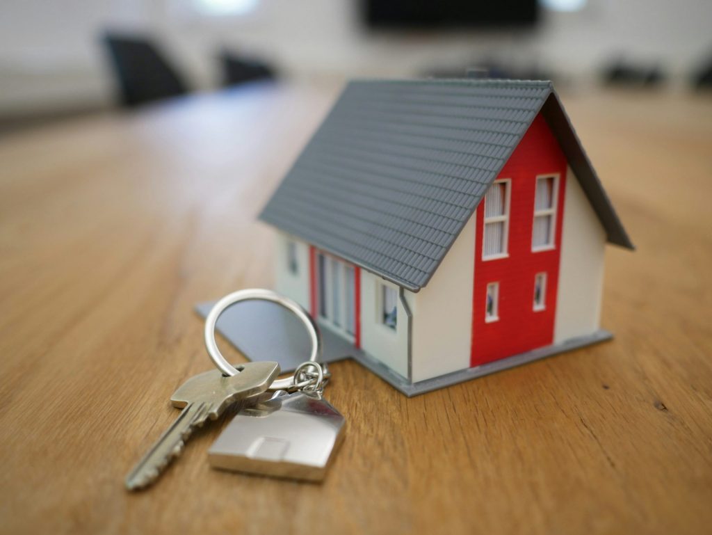 Miniatur eines weißen und roten Holzhauses auf einem braunen Tisch